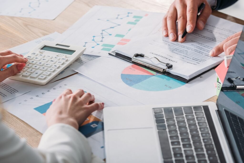 partial view of man studying loan agreement and businesswoman using calculator while sitting at